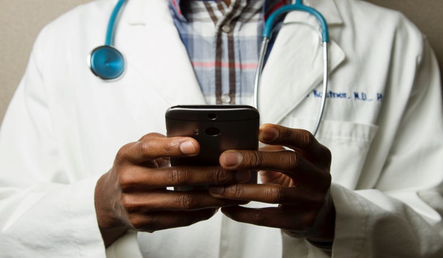 Doctor using remote patient monitoring app on mobile phone